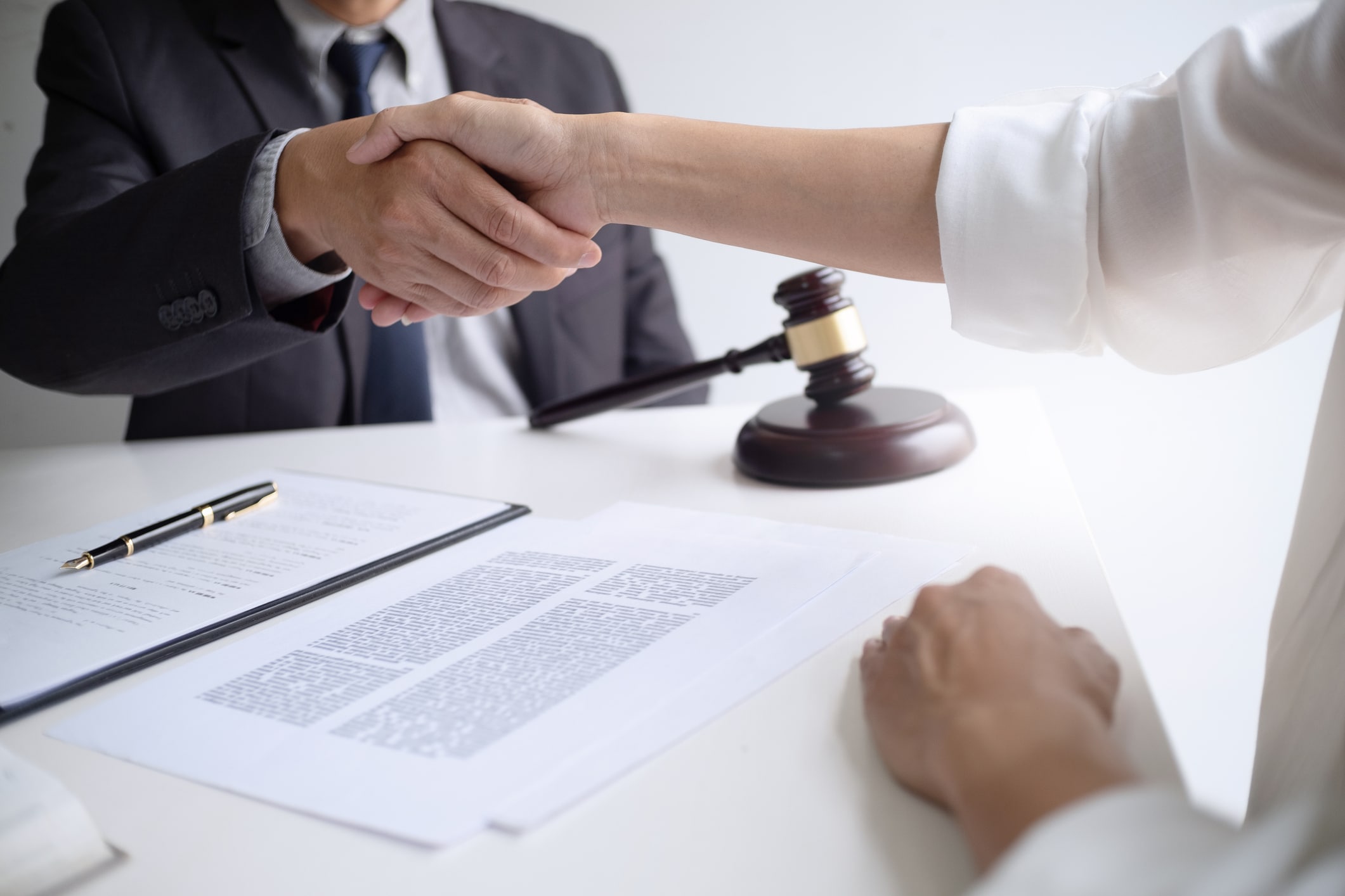 lawyer with client hands shaking in courtroom, legal and justice concept.